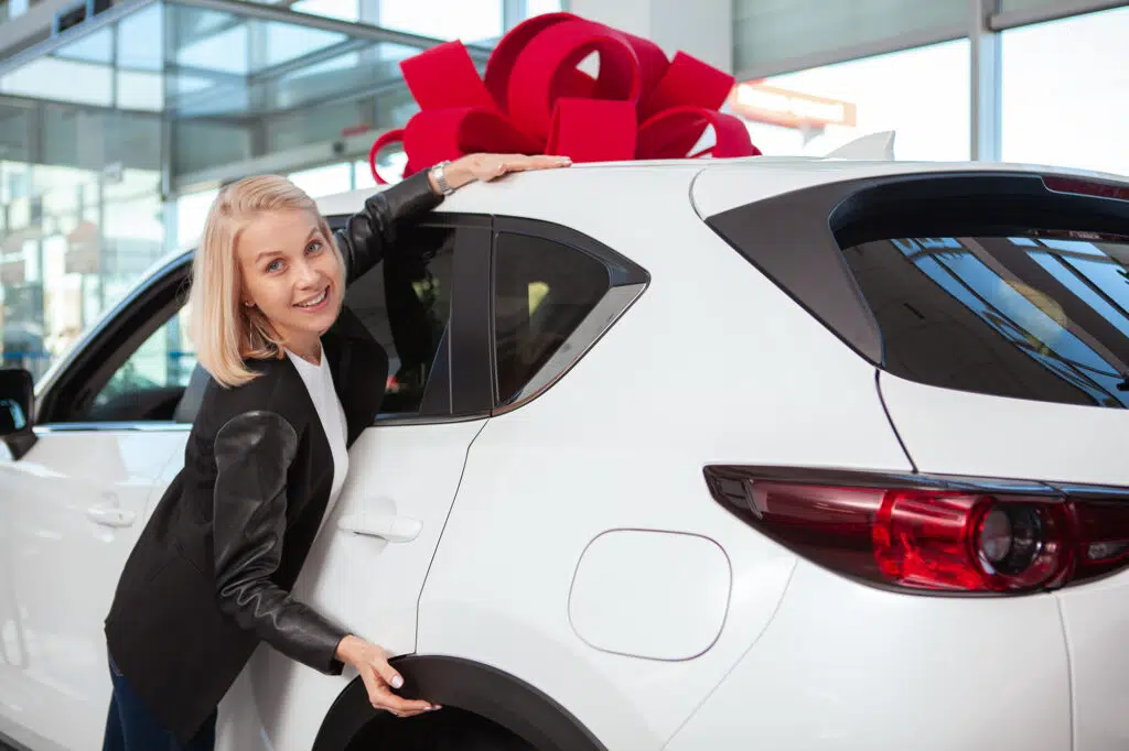 mulher feliz com seu carro novo que ganhou de presente